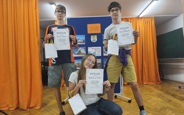 Trójka uczestników konkurs, dwóch chłopców i dziewczynka pozują do zdjęcia z dyplomami
